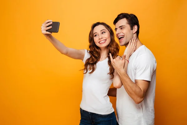 Happy young lovely couple posing together while making selfie — Stock Photo, Image