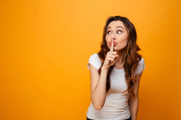 Mystery brunette woman in t-shirt showing silence gesture — Stock Photo, Image