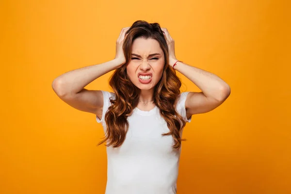 Ontevreden ernstige brunette vrouw in t-shirt houden van haar hoofd — Stockfoto