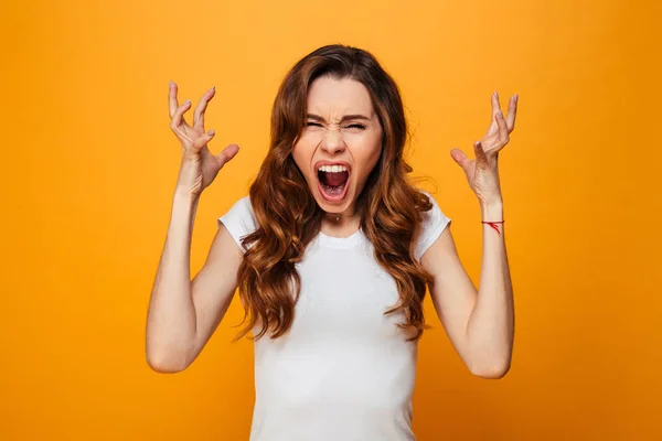Angry brunette woman in t-shirt screaming and looking at camera — Stock Photo, Image