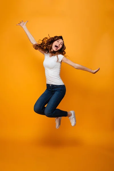 Imagem de comprimento total da mulher morena alegre em t-shirt jumping — Fotografia de Stock