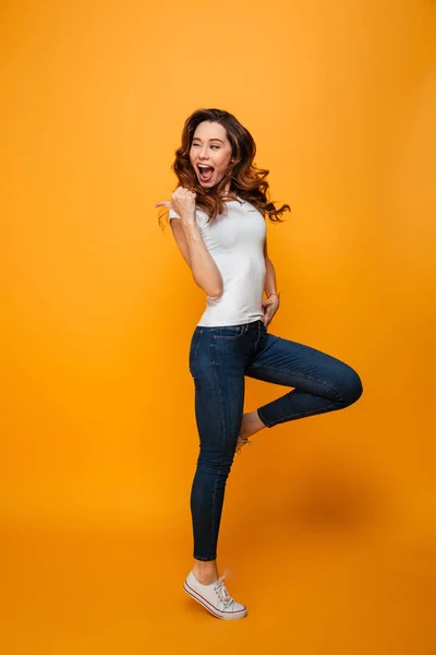 Full length image of Joyful brunette woman in t-shirt jumping — Stock Photo, Image