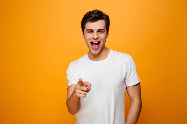 Homme heureux en t-shirt pointant et regardant la caméra — Photo