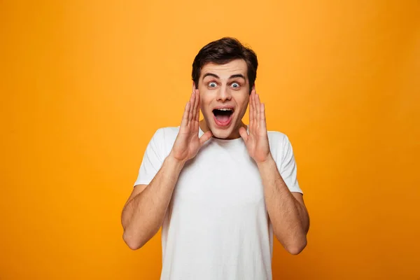 Hombre feliz en camiseta gritando con los brazos cerca de la boca —  Fotos de Stock