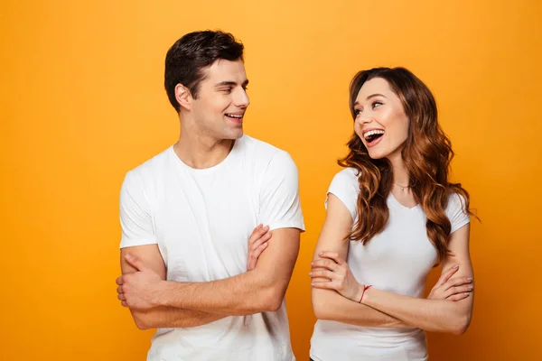 Портрет веселой молодой пары, стоящей со сложенными руками — стоковое фото