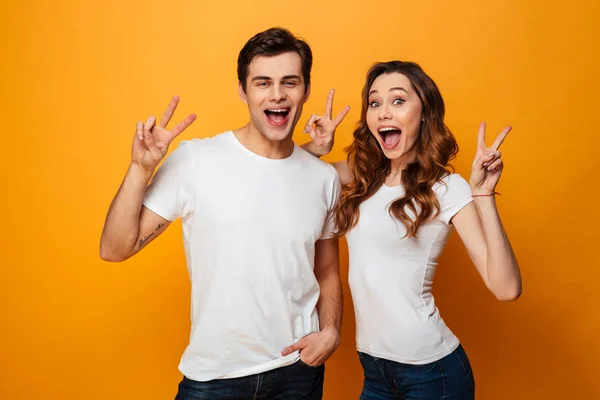 Retrato de una feliz pareja joven mostrando un gesto de paz —  Fotos de Stock