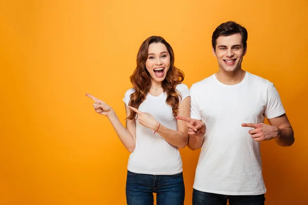 Porträt eines glücklichen jungen Paares, das mit dem Finger wegzeigt — Stockfoto