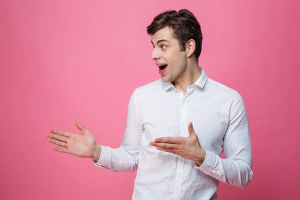 Young man standing isolated over pink background. — Stock Photo, Image
