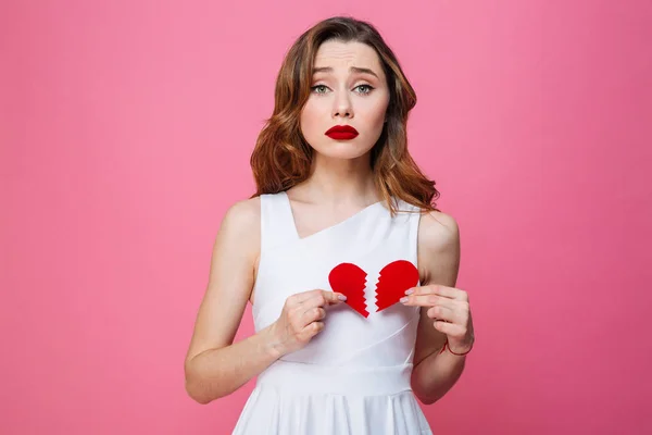 Young sad woman holding broken heart. Looking camera. — Stock Photo, Image