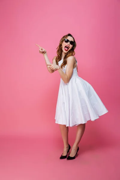 Underbara kaukasisk kvinna i klänning och solglasögon pekar finger — Stockfoto