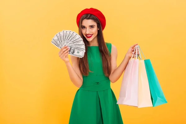 Joven alegre sosteniendo dinero y bolsas de compras —  Fotos de Stock