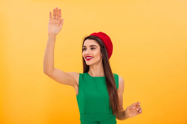 Fröhliche junge Frau winkt Freunden zu. — Stockfoto