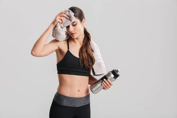 Joven deportista cansado en chándal bebiendo agua y limpiando s — Foto de Stock