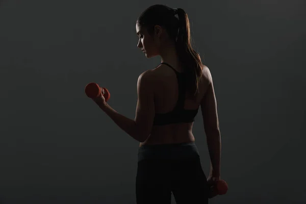 Imagen de la espalda de una mujer delgada y deportiva haciendo ejercicios con pequeños —  Fotos de Stock