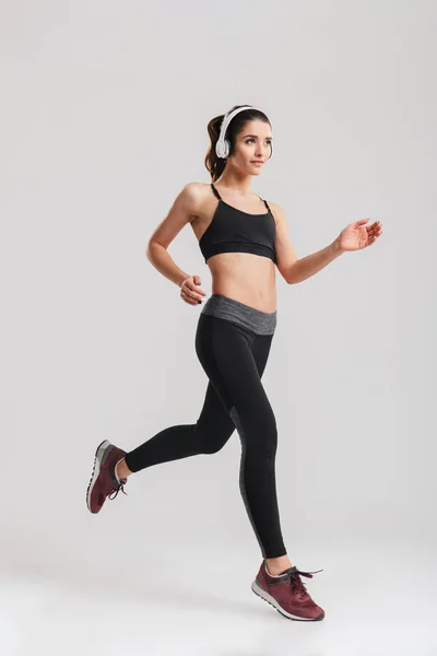 Imagem completa de mulher esportiva em corrida de traje de treino e liste — Fotografia de Stock