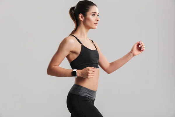 Foto de la mujer de fitness delgada corriendo o haciendo ejercicio con el reloj en — Foto de Stock