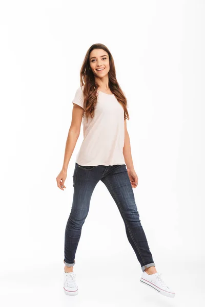 Full längd bilden av leende brunett kvinna i t-shirt promenader — Stockfoto