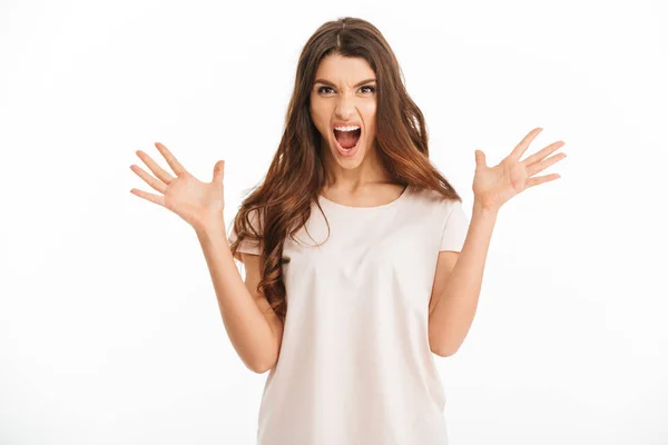 Boos brunette vrouw in t-shirt schreeuwen en kijken naar camera — Stockfoto