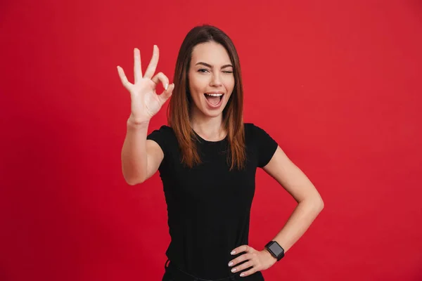 Portrait of a joyful casual girl showing ok gesture — Stock Photo, Image