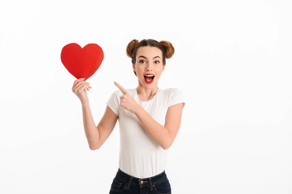 Portrait of an excited casual girl pointing finger at heart — Stock Photo, Image