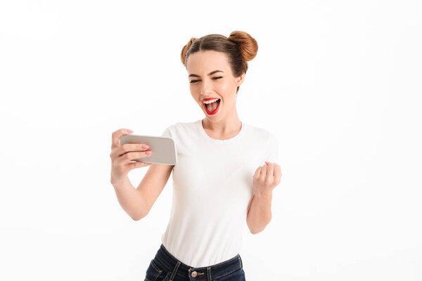 Portrait of a joyful casual girl looking at mobile phone