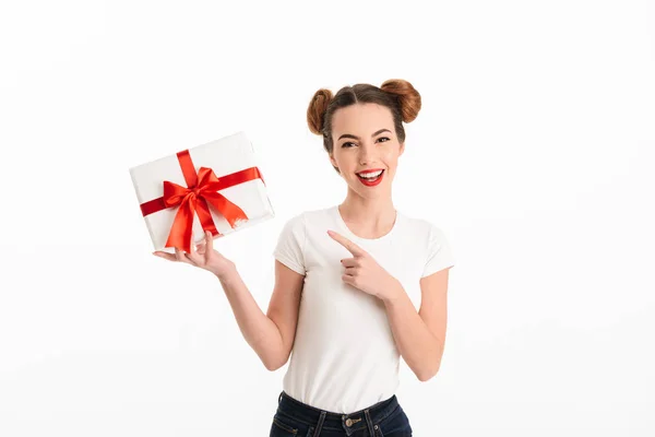 Porträt eines glücklichen, lässigen Mädchens, das mit dem Finger auf ein Geschenk zeigt — Stockfoto