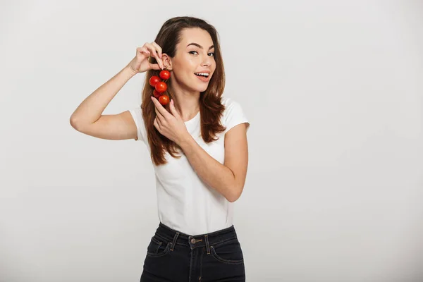Ritratto di una bella giovane donna con pomodori ciliegini in mano — Foto Stock