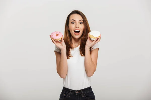 Portrait of a happy young woman holding donuts — Stock Photo, Image