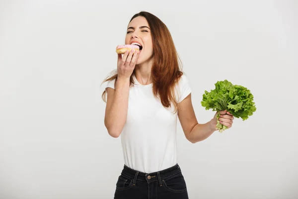 Porträt einer hungrigen jungen Frau, die einen Donut isst — Stockfoto