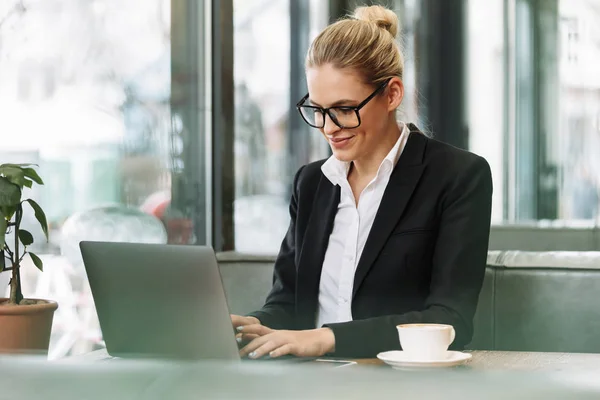 Smiling blonde business woman using laptop computer. — Stock Photo, Image