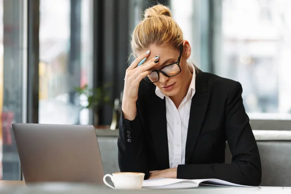 Femme d'affaires concentrée écrivant des notes dans un carnet . — Photo