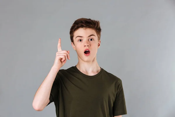 Porträtt av en upphetsad manlig tonåring klädd i t-shirt pekar — Stockfoto