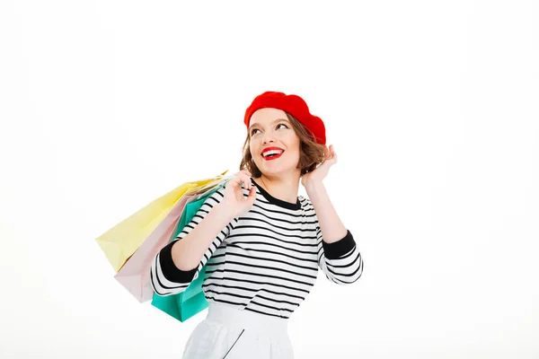 Happy gingembre femme avec des paquets corrige la coiffure et détourner les yeux — Photo