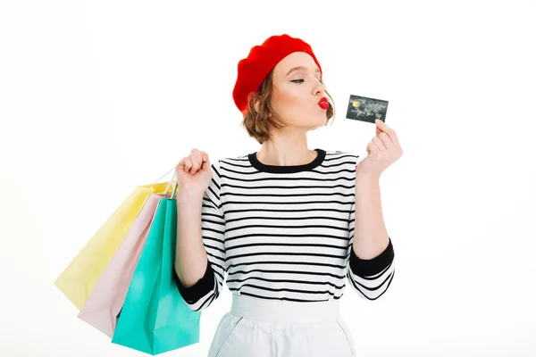 Игровая рыжая женщина держит пакеты и играет с кредитной картой — стоковое фото