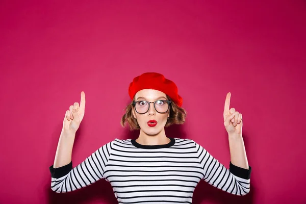 Förvånad över ingefära kvinna i glasögon pekar uppåt — Stockfoto