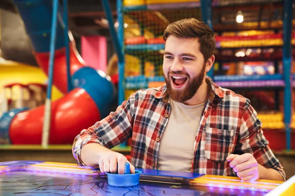 Leende ung man spela airhockey — Stockfoto