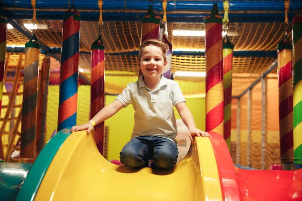 Felice bambino seduto su uno scivolo — Foto Stock