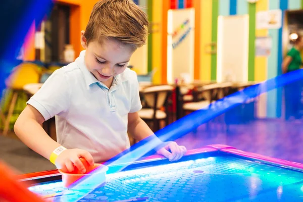 Mosolygó kis fiú játék air hockey — Stock Fotó