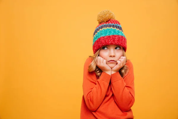 Nespokojený dívka v svetr a čepice leží na ruce — Stock fotografie