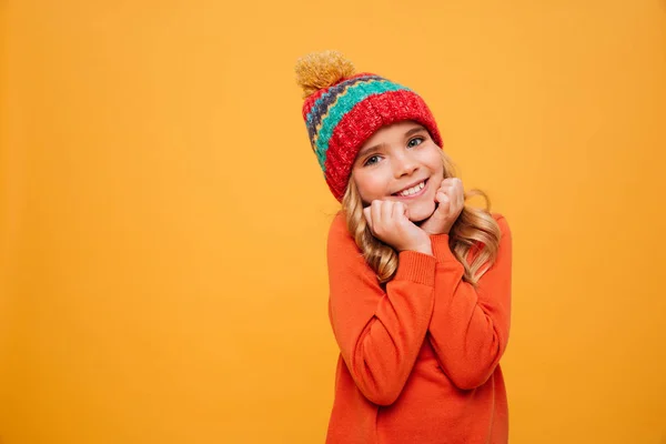 Pleased girl in sweater and hat reclines on her arms — Stock Photo, Image