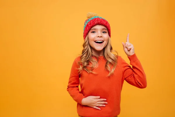 Hladová šťastná mladá dívka v svetr a čepice drží bříško — Stock fotografie