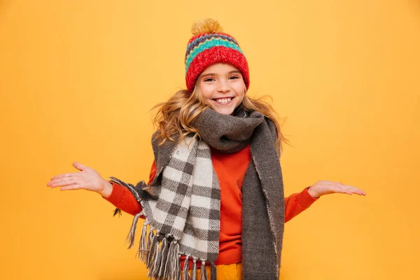 Ευτυχισμένος κορίτσι σε πουλόβερ, κασκόλ και καπέλο σηκώνει τους ώμους τους ώμους της — Φωτογραφία Αρχείου