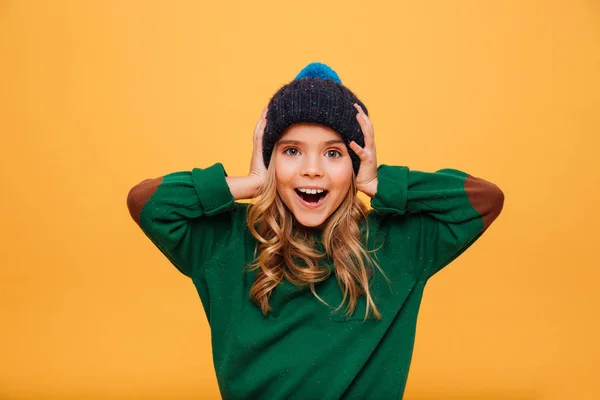 Surprised happy Young girl in sweater and hat holding head — Stock Photo, Image