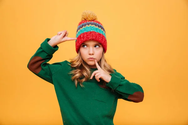 Fille sérieuse en pull et chapeau avec les doigts sur le temple — Photo