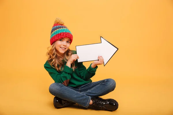 Piacevole Giovane ragazza in maglione e cappello seduto sul pavimento — Foto Stock