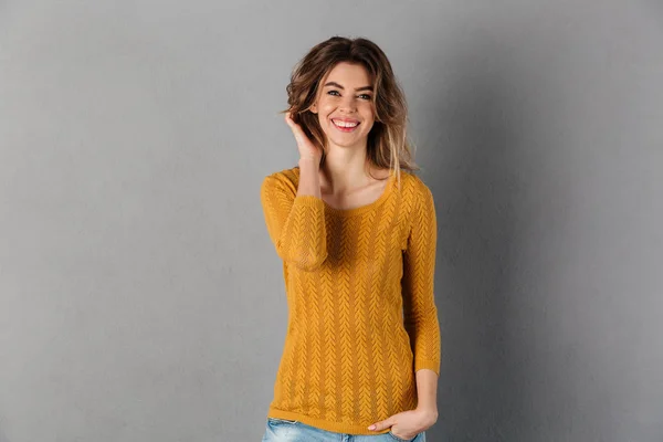 Lycklig kvinna i tröja poserar med arm i ficka — Stockfoto
