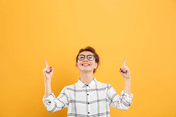 Retrato de mulher sorridente em camisa xadrez apontando dois dedos para cima — Fotografia de Stock