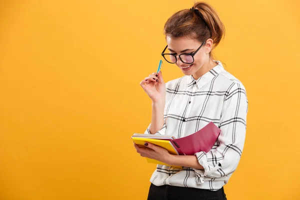 Mujer estudiante con cabello castaño en moño estudiando y mirando no —  Fotos de Stock