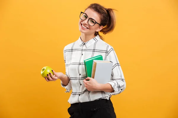 Foto di felice donna sorridente posa davanti alla macchina fotografica con libri e strappare — Foto Stock