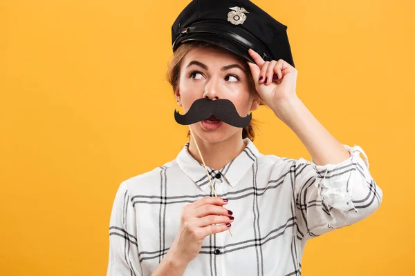 Retrato de mujer divertida en camisa a cuadros y gorra de policía sosteniendo pa — Foto de Stock